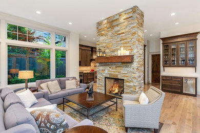 フェニックスにある高級なトランジショナルスタイルのおしゃれなリビングのホームバー (白い壁、淡色無垢フローリング、両方向型暖炉、石材の暖炉まわり、ベージュの床) の写真