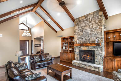 Large transitional open concept dark wood floor living room photo in Omaha with beige walls, a standard fireplace, a stone fireplace and a media wall