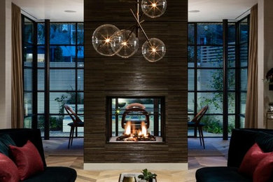 Inspiration for a large contemporary formal living room in London with green walls, medium hardwood flooring, a two-sided fireplace, a wooden fireplace surround and a built-in media unit.