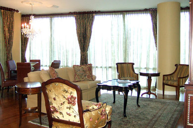 Ejemplo de salón para visitas abierto clásico grande sin chimenea con suelo de madera en tonos medios, televisor retractable y paredes beige