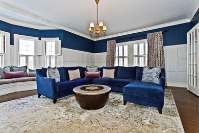 Modelo de salón para visitas cerrado contemporáneo grande sin chimenea con paredes azules, suelo de madera en tonos medios y suelo marrón