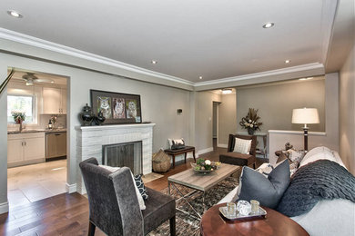 Klassisches Wohnzimmer mit beiger Wandfarbe, braunem Holzboden, Kamin und Kaminumrandung aus Backstein in Toronto