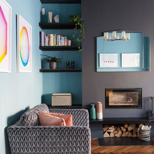 Design ideas for a medium sized contemporary enclosed living room in London with blue walls, medium hardwood flooring and a wood burning stove.