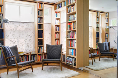Eklektisk inredning av ett litet allrum med öppen planlösning, med ett bibliotek, beige väggar och ljust trägolv