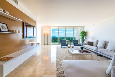Inspiration for a large contemporary open concept marble floor and beige floor living room remodel in Miami with white walls and a wall-mounted tv