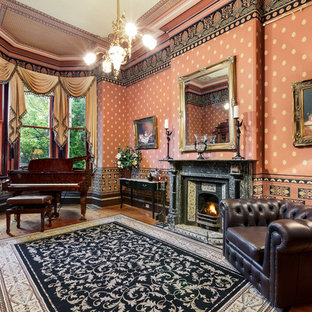 Inspiration for a victorian enclosed living room in Melbourne with a music area, red walls, dark hardwood floors, a standard fireplace, a stone fireplace surround and brown floor.