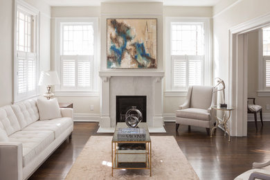 Inspiration for a mid-sized transitional enclosed dark wood floor living room remodel in New Orleans with beige walls and a standard fireplace