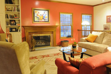 Example of a classic carpeted living room design in New York with orange walls, a standard fireplace and a brick fireplace
