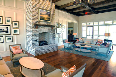 На фото: гостиная комната в классическом стиле с белыми стенами, светлым паркетным полом, стандартным камином и фасадом камина из кирпича с