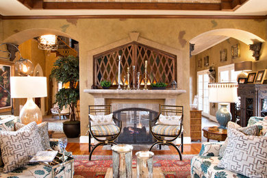 Example of a large tuscan formal and enclosed medium tone wood floor and brown floor living room design in Charlotte with yellow walls, a two-sided fireplace, a stone fireplace and no tv