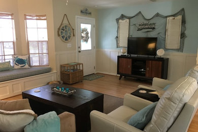 Imagen de salón abierto marinero de tamaño medio con paredes azules, suelo de madera clara y televisor independiente
