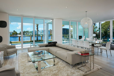 Großes, Repräsentatives, Offenes Modernes Wohnzimmer ohne Kamin mit beiger Wandfarbe, hellem Holzboden und TV-Wand in Miami