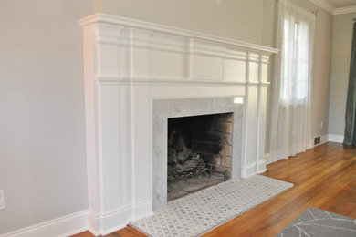 Small elegant enclosed medium tone wood floor living room photo in Other with a wood fireplace surround and no tv