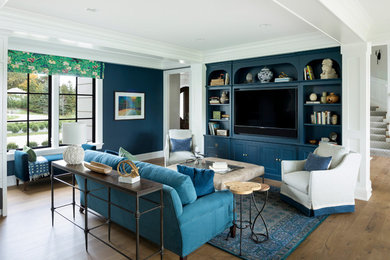 Modelo de salón abierto clásico renovado de tamaño medio con paredes azules, suelo de madera en tonos medios, televisor colgado en la pared y suelo marrón