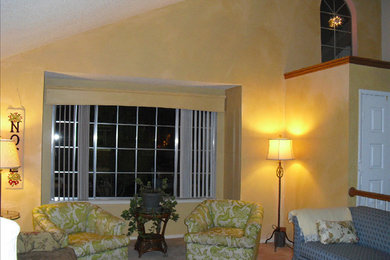 Modelo de salón ecléctico sin chimenea con paredes amarillas y moqueta