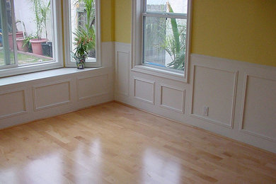 Example of a trendy light wood floor living room design in New York with yellow walls