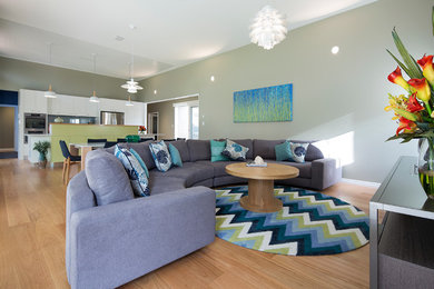 Medium sized contemporary open plan living room in Brisbane with green walls, medium hardwood flooring, no fireplace and a freestanding tv.
