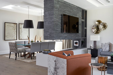 Diseño de salón para visitas cerrado contemporáneo de tamaño medio con paredes beige, suelo de madera clara, chimenea de doble cara, televisor colgado en la pared y suelo beige