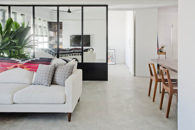 Ispirazione per un soggiorno contemporaneo di medie dimensioni e stile loft con pareti bianche, pavimento in cemento, TV a parete e pavimento grigio