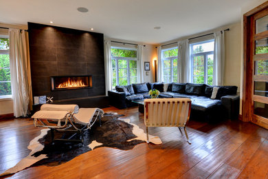 モントリオールにあるコンテンポラリースタイルのおしゃれなLDK (ベージュの壁、濃色無垢フローリング、横長型暖炉、茶色い床、タイルの暖炉まわり) の写真