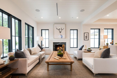 Living room - transitional open concept medium tone wood floor, brown floor and shiplap ceiling living room idea in Los Angeles with white walls, a standard fireplace and a stone fireplace