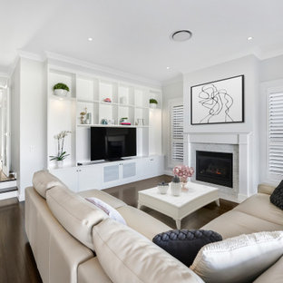 Inspiration for a large transitional open concept living room in Sydney with white walls, dark hardwood floors, a standard fireplace, a brick fireplace surround, a freestanding tv and brown floor.