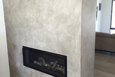 Example of a large minimalist living room design in Toronto with a two-sided fireplace and a concrete fireplace