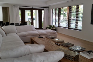 Foto di un grande soggiorno stile marino aperto con pareti bianche, parquet chiaro, nessun camino, TV a parete e pavimento marrone