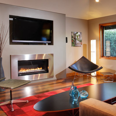 Example of a mid-sized trendy formal and enclosed medium tone wood floor living room design in Sacramento with a ribbon fireplace, a wall-mounted tv, white walls and a metal fireplace