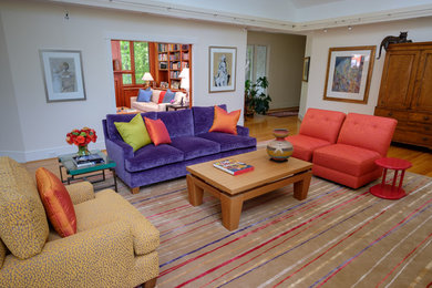 This is an example of a large contemporary open plan living room in Raleigh with light hardwood flooring.