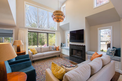 Example of a large trendy open concept medium tone wood floor and brown floor living room design in Boston with a standard fireplace, a stone fireplace and a wall-mounted tv