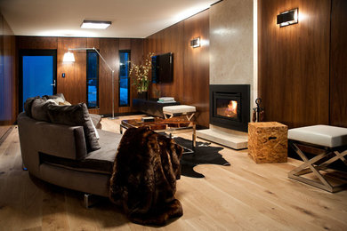 Diseño de salón para visitas cerrado contemporáneo de tamaño medio con paredes marrones, suelo de madera en tonos medios, todas las chimeneas y televisor colgado en la pared