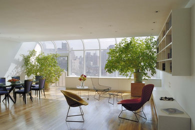 Photo of a large modern open plan living room in New York with white walls, light hardwood flooring and no fireplace.