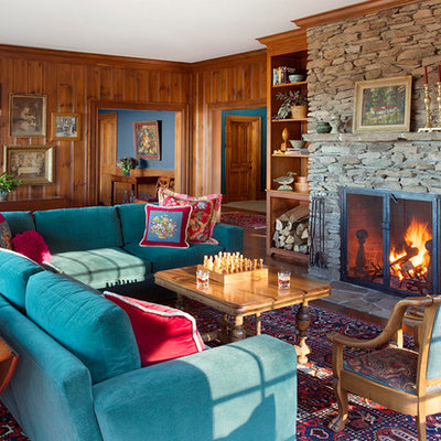 Large elegant enclosed medium tone wood floor living room photo in Boston with brown walls, a standard fireplace and a stone fireplace