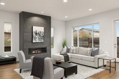 Example of a large trendy formal and open concept medium tone wood floor and brown floor living room design in Seattle with white walls, a ribbon fireplace and a tile fireplace