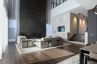 Пример оригинального дизайна: открытая гостиная комната в современном стиле с паркетным полом среднего тона, стандартным камином, фасадом камина из плитки и коричневым полом