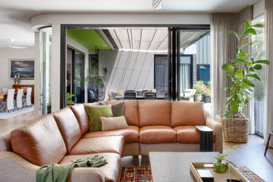 Großes, Repräsentatives, Offenes Modernes Wohnzimmer mit weißer Wandfarbe, braunem Holzboden und braunem Boden in Melbourne