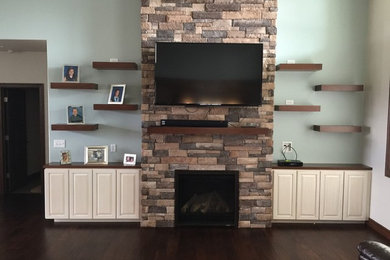 Inspiration for a large transitional open concept dark wood floor living room remodel in Other with blue walls, a standard fireplace, a brick fireplace and a wall-mounted tv