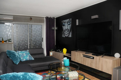 Example of a mid-sized trendy brown floor living room design in Toronto with black walls and a tv stand