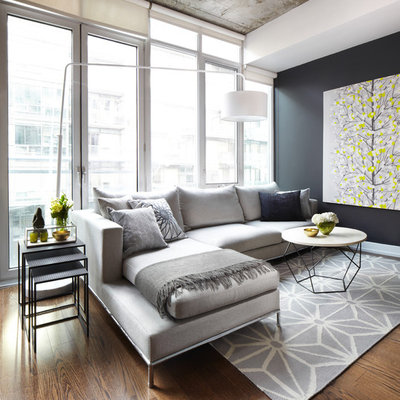 Trendy medium tone wood floor and brown floor living room photo in Dallas with black walls