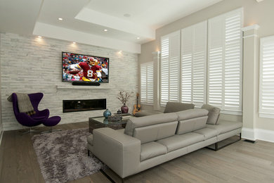 Photo of a medium sized contemporary enclosed living room in DC Metro with grey walls, dark hardwood flooring, a standard fireplace, a stone fireplace surround and a wall mounted tv.
