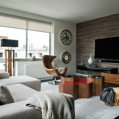 Trendy dark wood floor living room photo in New York with gray walls and a wall-mounted tv