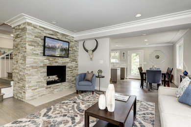 Example of a mid-sized trendy formal and open concept light wood floor living room design in DC Metro with beige walls, a standard fireplace, a stone fireplace and a wall-mounted tv
