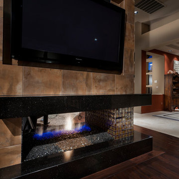 Contemporary see-through two-room granite fireplace with glass tile in firebox
