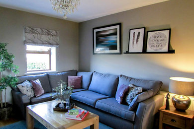 Immagine di un piccolo soggiorno design chiuso con pareti grigie, parquet chiaro, stufa a legna, parete attrezzata e pavimento marrone