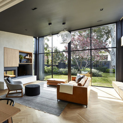 Living room - contemporary formal and open concept light wood floor living room idea in Adelaide with gray walls, a standard fireplace, a plaster fireplace and a tv stand
