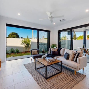 This is an example of a mid-sized contemporary formal open concept living room in Gold Coast - Tweed with white walls, ceramic floors, a freestanding tv and beige floor.