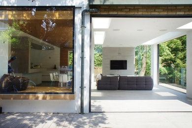 Idée de décoration pour un grand salon design ouvert avec un mur blanc, un sol en carrelage de céramique et un téléviseur encastré.