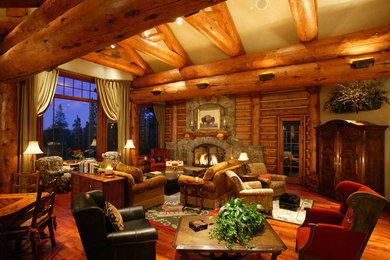 This is an example of a large rustic open plan living room in Denver with beige walls, medium hardwood flooring, a standard fireplace, a stone fireplace surround, no tv and brown floors.