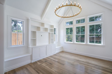 Example of a mid-sized classic enclosed medium tone wood floor and brown floor living room design in Jacksonville with white walls and no fireplace